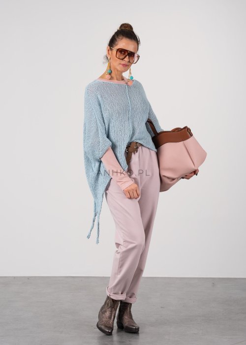 Pudrowe spodnie damskie chino o zwężanym kroju z podwijaną nogawką i paskiem, styl elegancki casual.