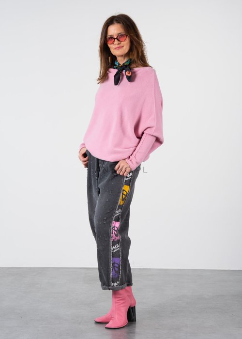 Pudroworóżowy sweter damski oversize o kroju nietoperzowym z asymetrycznym dołem, stylizacja z jeansami.