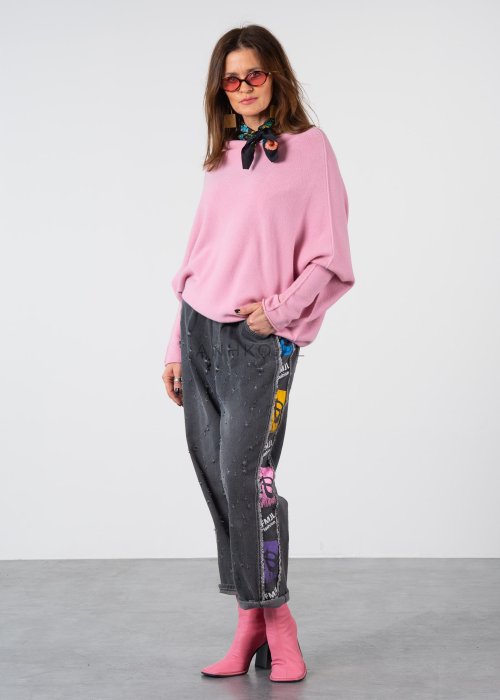Pudroworóżowy sweter damski oversize o kroju nietoperzowym z asymetrycznym dołem, stylizacja z jeansami.