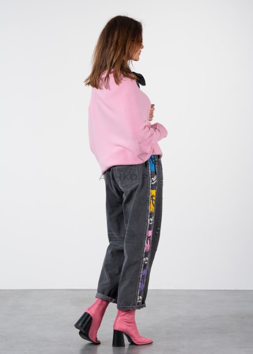 Pudroworóżowy sweter damski oversize o kroju nietoperzowym z asymetrycznym dołem, stylizacja z jeansami.