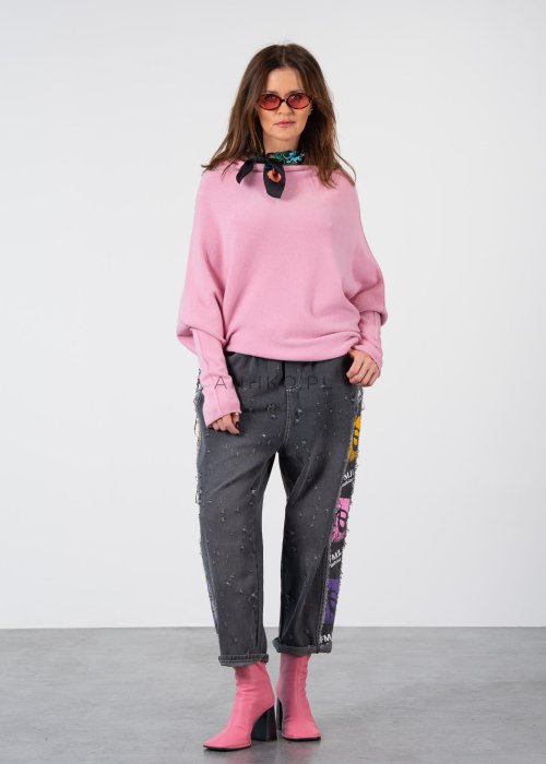 Pudroworóżowy sweter damski oversize o kroju nietoperzowym z asymetrycznym dołem, stylizacja z jeansami.