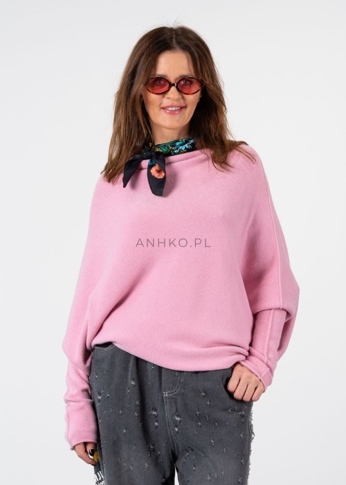 Pudroworóżowy sweter damski oversize o kroju nietoperzowym z asymetrycznym dołem, stylizacja z jeansami.