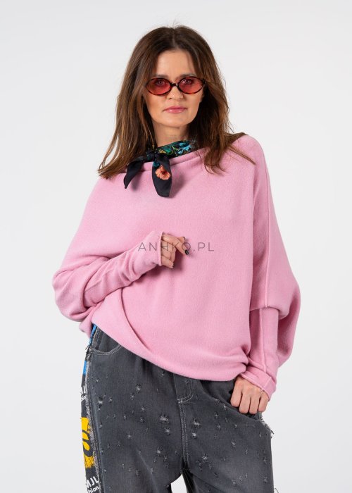 Pudroworóżowy sweter damski oversize o kroju nietoperzowym z asymetrycznym dołem, stylizacja z jeansami.