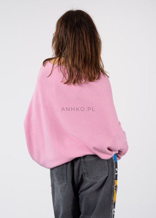 Pudroworóżowy sweter damski oversize o kroju nietoperzowym z asymetrycznym dołem, stylizacja z jeansami.