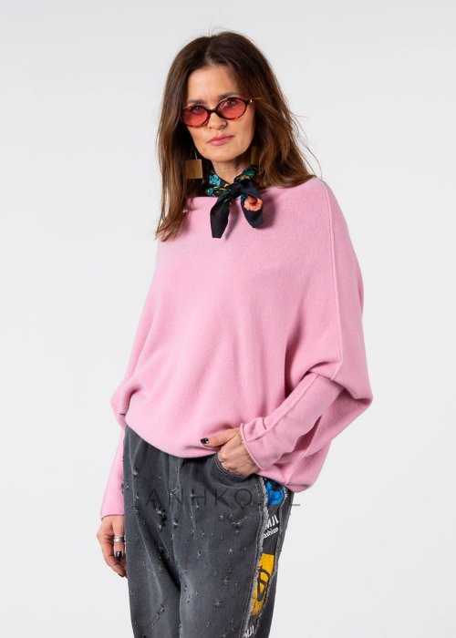 Pudroworóżowy sweter damski oversize o kroju nietoperzowym z asymetrycznym dołem, stylizacja z jeansami.