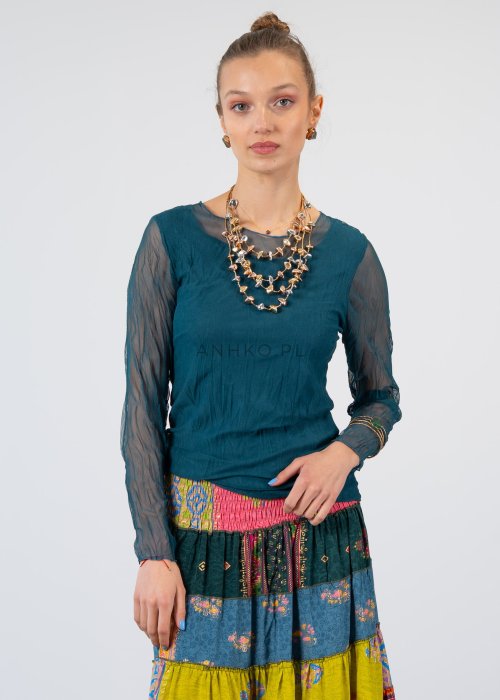 Morska bluzka damska z transparentnymi rękawami i dekoltem łódka, elegancka stylizacja z biżuterią i wzorzystą spódnicą.