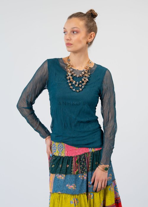 Morska bluzka damska z transparentnymi rękawami i dekoltem łódka, elegancka stylizacja z biżuterią i wzorzystą spódnicą.