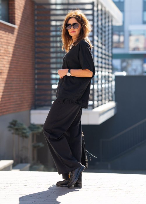 Czarne spodnie dresowe damskie z szeroką nogawką i elastyczną talią z troczkiem, stylizacja miejska