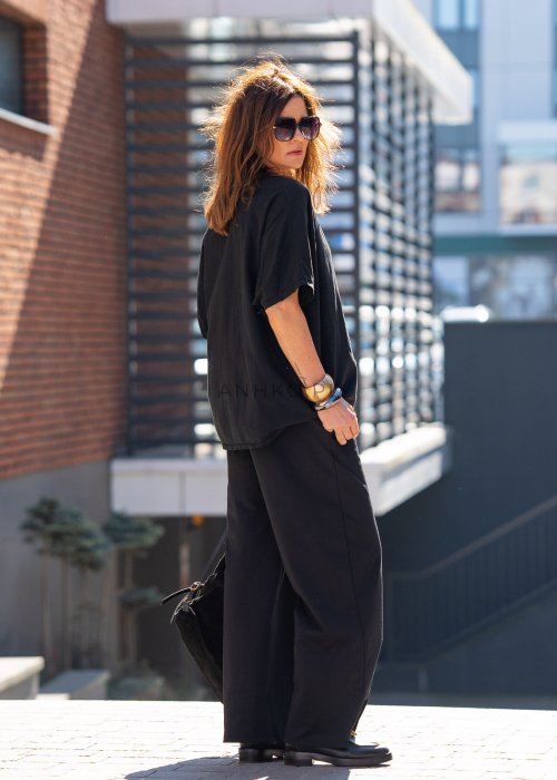 Czarne spodnie dresowe damskie z szeroką nogawką i elastyczną talią z troczkiem, stylizacja miejska