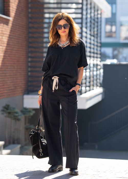 Czarne spodnie dresowe damskie z szeroką nogawką i elastyczną talią z troczkiem, stylizacja miejska