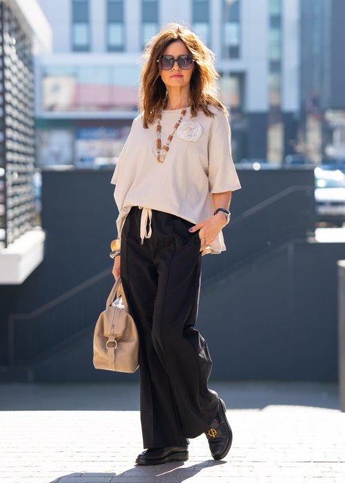 Czarne spodnie dresowe damskie z szeroką nogawką i elastyczną talią z troczkiem, stylizacja miejska