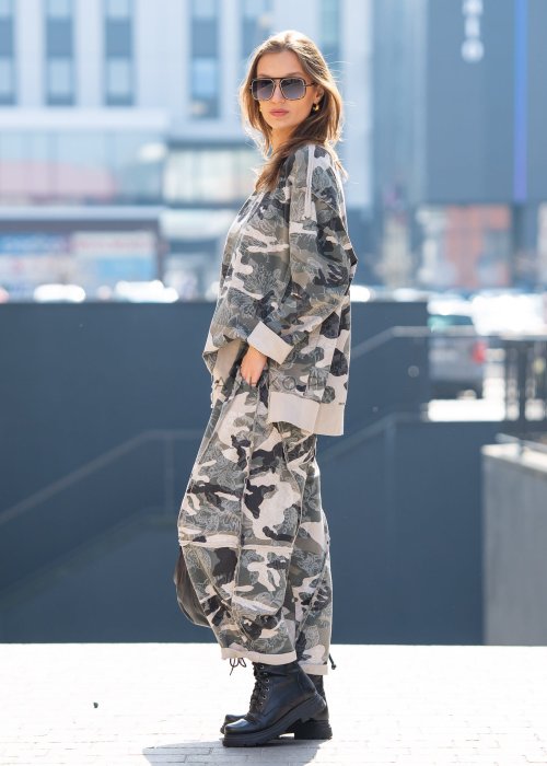 Damska bluza oversize w print moro z motywem roślinnym, z długim rękawem i okrągłym dekoltem. Stylizacja miejska zestawiona ze spodniami w tym samym wzorze i botkami.