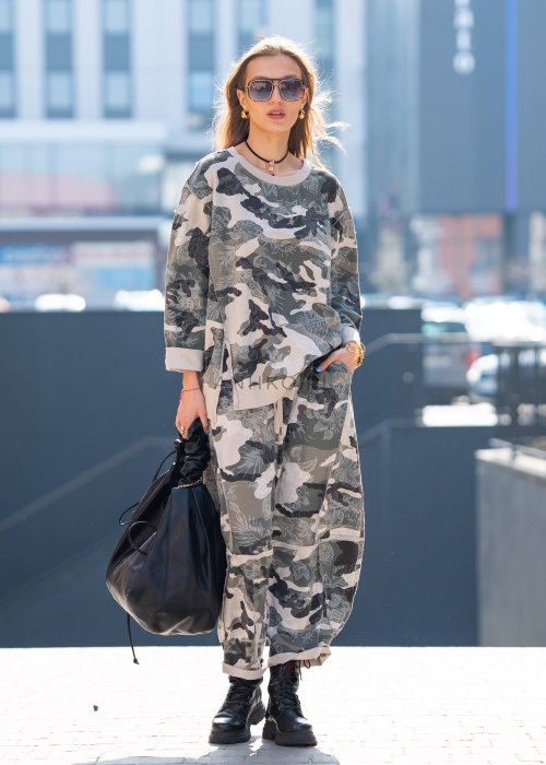 Damska bluza oversize w print moro z motywem roślinnym, z długim rękawem i okrągłym dekoltem. Stylizacja miejska zestawiona ze spodniami w tym samym wzorze i botkami.