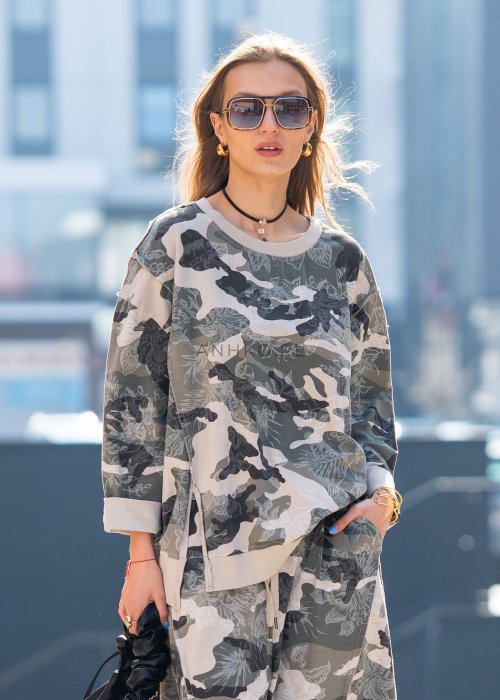 Damska bluza oversize w print moro z motywem roślinnym, z długim rękawem i okrągłym dekoltem. Stylizacja miejska zestawiona ze spodniami w tym samym wzorze i botkami.