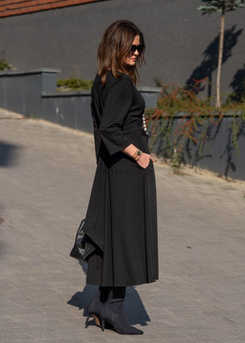Czarna sukienka midi z wiązaniem w talii i rękawem 3/4, o lekko rozkloszowanym kroju. Stylizacja z botkami i torebką w eleganckim, miejskim wydaniu.