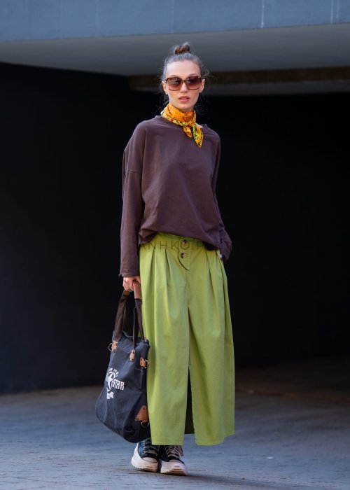 Czekoladowa bluza damska oversize z długim rękawem i subtelną naszywką na froncie. Luźny fason w stylizacji z szerokimi spodniami i apaszką w miejskim stylu.