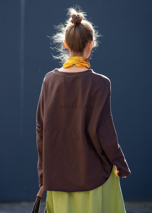 Czekoladowa bluza damska oversize z długim rękawem i subtelną naszywką na froncie. Luźny fason w stylizacji z szerokimi spodniami i apaszką w miejskim stylu.