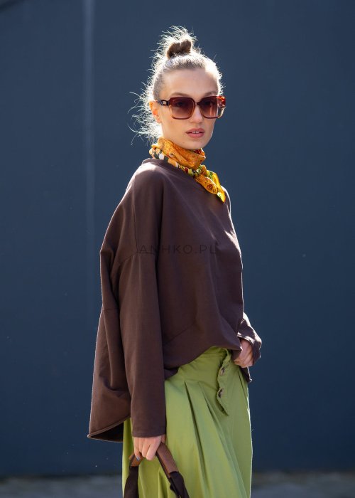 Czekoladowa bluza damska oversize z długim rękawem i subtelną naszywką na froncie. Luźny fason w stylizacji z szerokimi spodniami i apaszką w miejskim stylu.