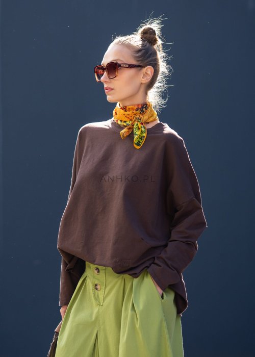 Czekoladowa bluza damska oversize z długim rękawem i subtelną naszywką na froncie. Luźny fason w stylizacji z szerokimi spodniami i apaszką w miejskim stylu.