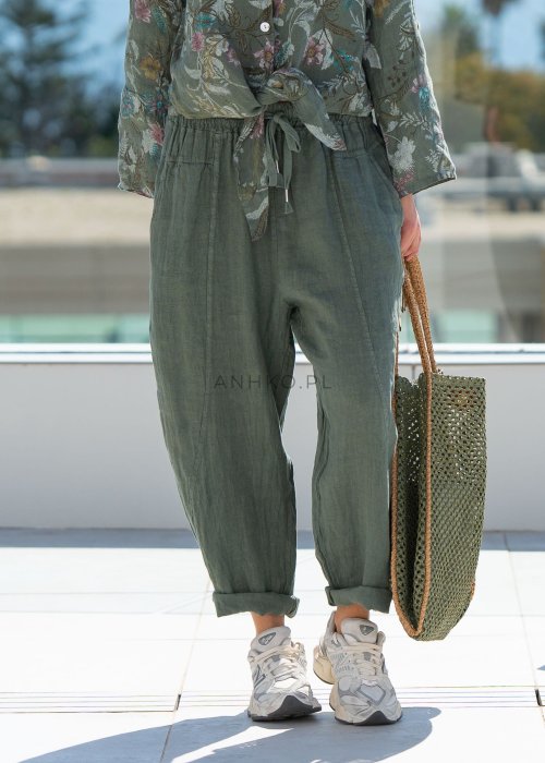 Lniane spodnie damskie w kolorze khaki o luźnym kroju RelaxFit z elastycznym pasem i troczkiem, stylizowane z koszulą i torbą w naturalnym, miejskim looku.