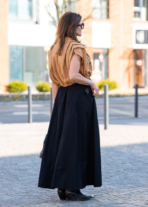 Czarna spódnica maxi o rozkloszowanym fasonie z miękko układającego się materiału. Model z wysokim stanem i szerokim paskiem podkreśla talię, tworząc elegancką i kobiecą sylwetkę idealną zarówno do casualowych, jak i bardziej wyrazistych stylizacji.