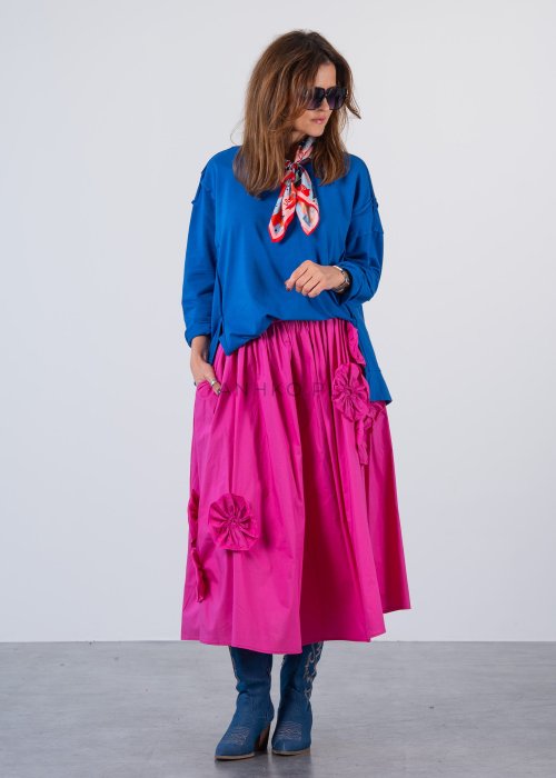 Damska bluza oversize w intensywnym niebieskim kolorze z długim rękawem i okrągłym dekoltem. Stylizacja zestawiona z różową spódnicą i okularami przeciwsłonecznymi.