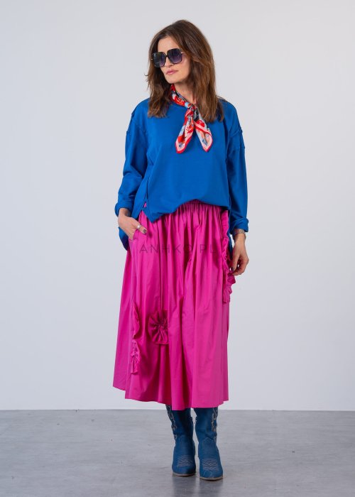 Damska bluza oversize w intensywnym niebieskim kolorze z długim rękawem i okrągłym dekoltem. Stylizacja zestawiona z różową spódnicą i okularami przeciwsłonecznymi.