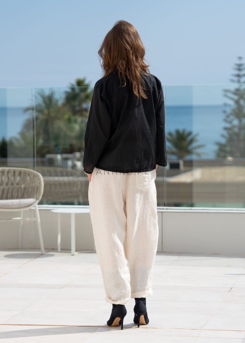 Śmietankowe spodnie lniane damskie o luźnym kroju RelaxFit z elastycznym pasem i troczkiem, stylizowane z czarną koszulą i botkami w eleganckim, minimalistycznym looku.