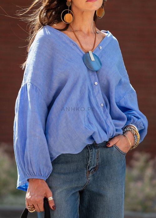Niebieska koszula lniana oversize z dekoltem V i guzikami, stylizowana z jeansami.