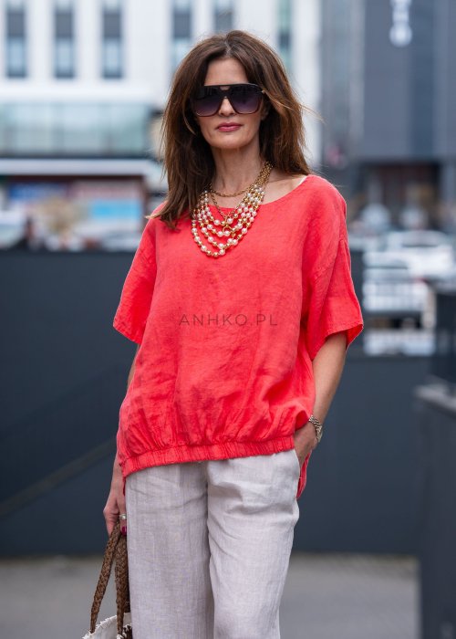Koralowa lniana bluzka oversize ze ściągaczem u dołu, stylizowana z biżuterią i miejskim outfitem w energetycznym wydaniu.