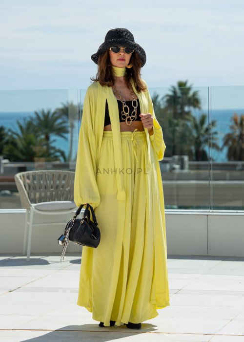 Żółte spodnie damskie z szeroką, lejącą nogawką i elastycznym pasem, stylizowane z czarnym topem w nowoczesnym, miejskim stylu.