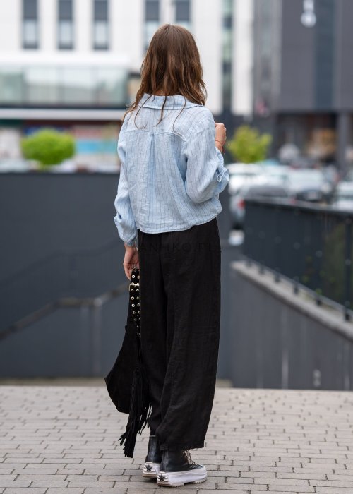 Czarne lniane spodnie damskie z szeroką nogawką i elastycznym pasem ze sznurkiem. Stylizacja casual z lekką bluzką i balerinami w miejskim wydaniu.