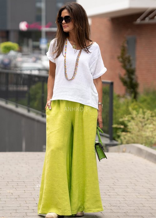 Limonkowe lniane spodnie damskie z bardzo szeroką nogawką i gumą w pasie, model z kieszeniami po bokach w swobodnej miejskiej stylizacji.