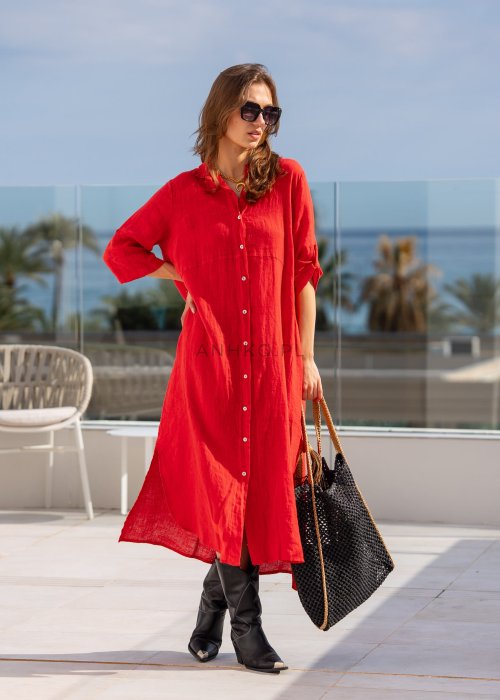 Czerwona lniana sukienka maxi w stylu szmizjerki, zapinana na guziki, o luźnym fasonie oversize, stylizowana z wysokimi kozakami i torbą.