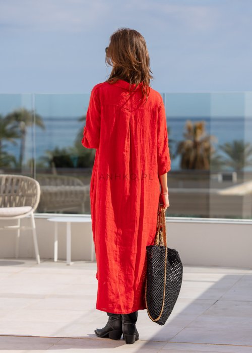 Czerwona lniana sukienka maxi w stylu szmizjerki, zapinana na guziki, o luźnym fasonie oversize, stylizowana z wysokimi kozakami i torbą.