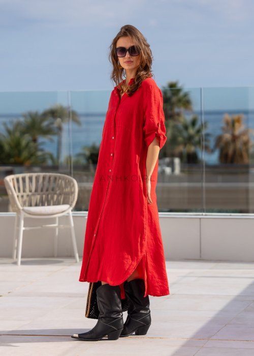 Czerwona lniana sukienka maxi w stylu szmizjerki, zapinana na guziki, o luźnym fasonie oversize, stylizowana z wysokimi kozakami i torbą.