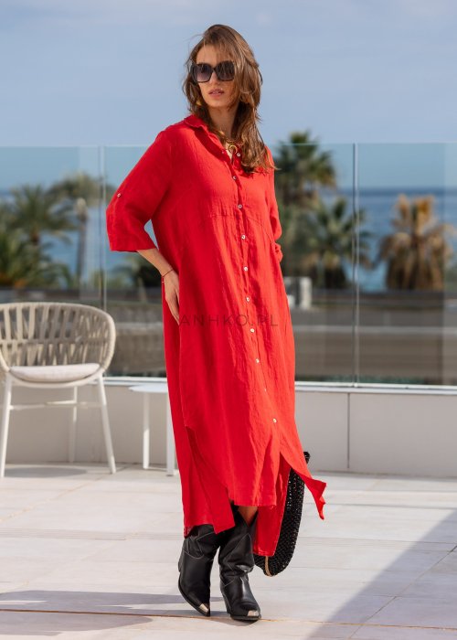 Czerwona lniana sukienka maxi w stylu szmizjerki, zapinana na guziki, o luźnym fasonie oversize, stylizowana z wysokimi kozakami i torbą.