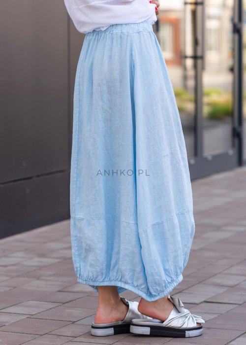 Błękitna spódnica lniana maxi z gumką w pasie i marszczonym dołem, o luźnym fasonie. Stylizacja z białą koszulą i klapkami na platformie.