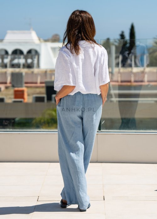 Biała koszula lniana damska o luźnym kroju z szerokimi rękawami i kołnierzykiem. Lekki, naturalny materiał pięknie układa się na sylwetce.