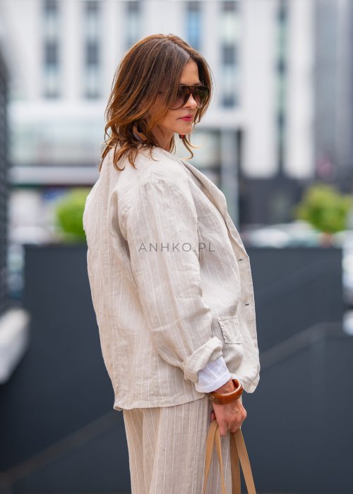 Lniana marynarka damska w kremowym kolorze z delikatnymi prążkami, klasyczny krój oversize, stylizacja miejska z naturalnymi dodatkami.