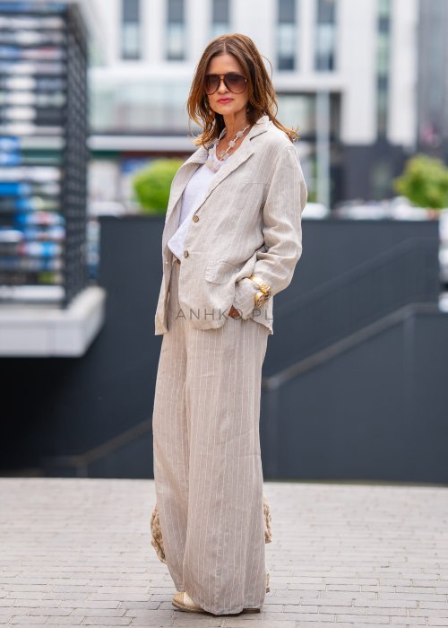 Lniana marynarka damska w kremowym kolorze z delikatnymi prążkami, klasyczny krój oversize, stylizacja miejska z naturalnymi dodatkami.