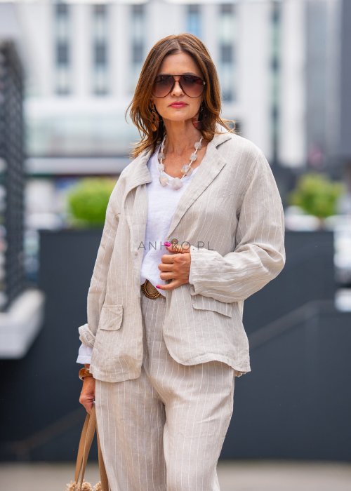 Lniana marynarka damska w kremowym kolorze z delikatnymi prążkami, klasyczny krój oversize, stylizacja miejska z naturalnymi dodatkami.