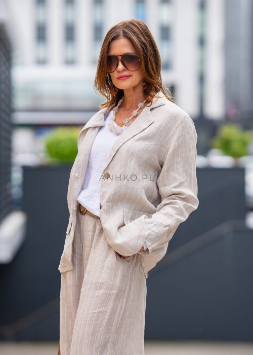 Lniana marynarka damska w kremowym kolorze z delikatnymi prążkami, klasyczny krój oversize, stylizacja miejska z naturalnymi dodatkami.