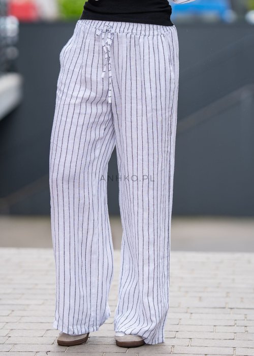 Spodnie lniane damskie w białym kolorze w pionowe paski z szerokimi nogawkami i elastycznym pasem. Stylizacja lekka i elegancka.