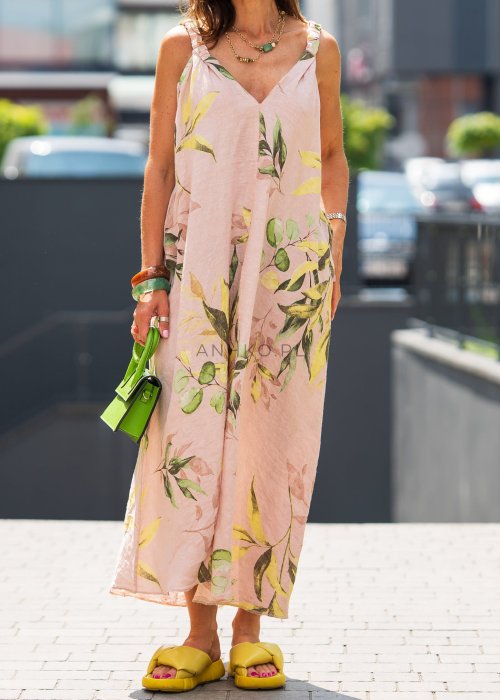 Jasnoróżowa damska sukienka lniana maxi z roślinnym printem i marszczonymi ramiączkami. Lekka, luźna forma z kieszeniami, prezentowana w miejskiej stylizacji.