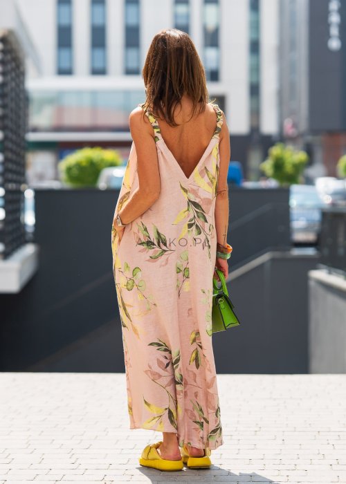 Jasnoróżowa damska sukienka lniana maxi z roślinnym printem i marszczonymi ramiączkami. Lekka, luźna forma z kieszeniami, prezentowana w miejskiej stylizacji.