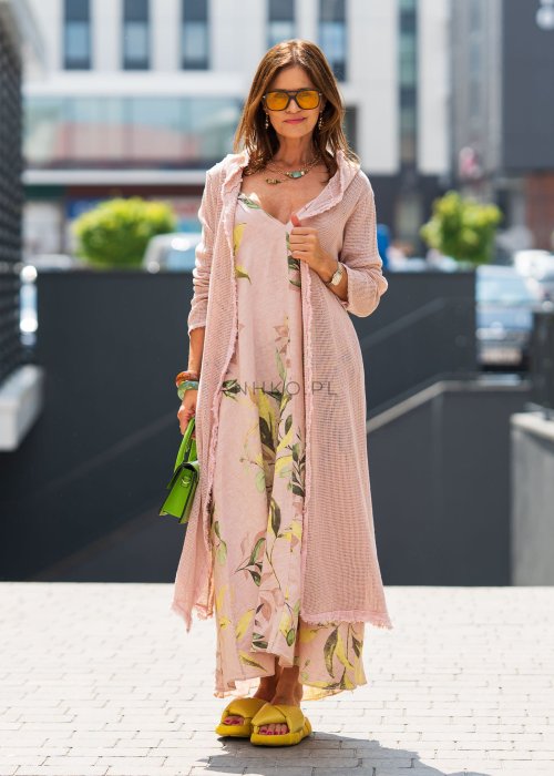 Jasnoróżowa damska sukienka lniana maxi z roślinnym printem i marszczonymi ramiączkami. Lekka, luźna forma z kieszeniami, prezentowana w miejskiej stylizacji.