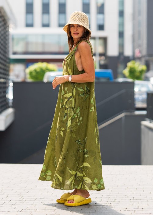Damska sukienka lniana maxi w zielonym kolorze z roślinnym printem i marszczonymi ramiączkami, luźny fason z kieszeniami, stylizacja miejska.