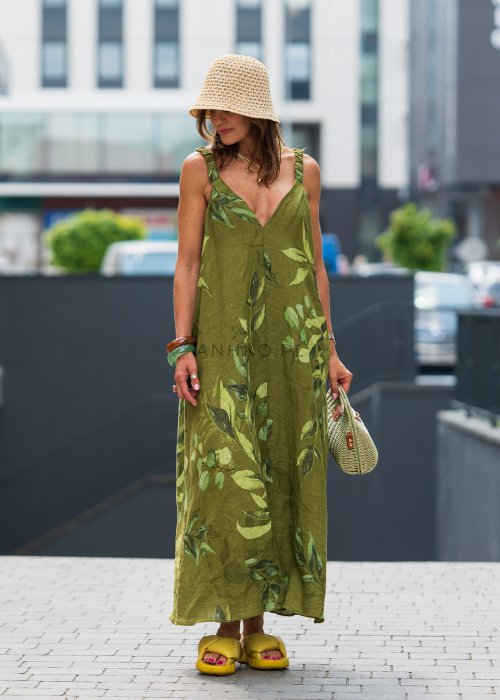 Damska sukienka lniana maxi w zielonym kolorze z roślinnym printem i marszczonymi ramiączkami, luźny fason z kieszeniami, stylizacja miejska.