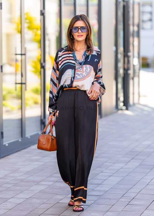 Czarne spodnie damskie z szeroką nogawką i elastyczną talią, ozdobione kontrastowymi brzoskwiniowymi lampasami.